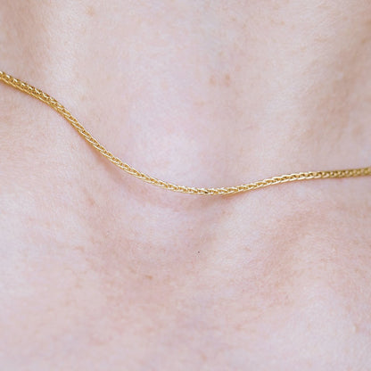 Gold necklace with a cyclamen pendant in a bracket